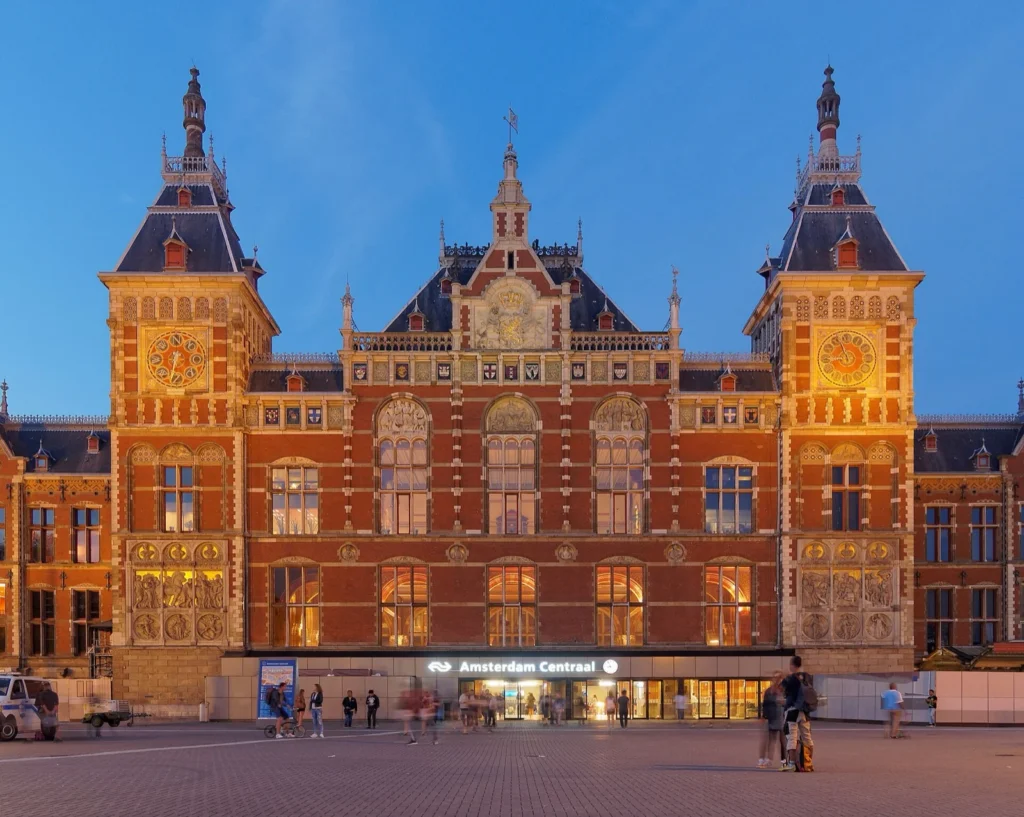 La facciata della stazione Amsterdam Centraal illuminata di sera