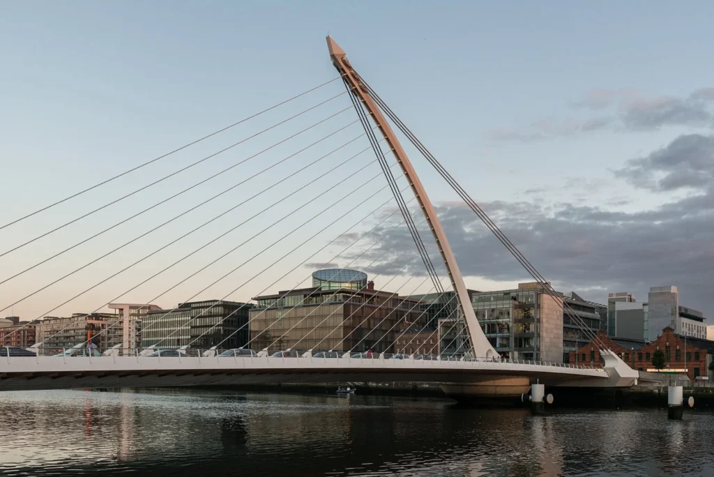 Il Samuel Beckett Bridge, ponte strallato bianco sul fiume Liffey a Dublino, con gli edifici della riva sullo sfondo