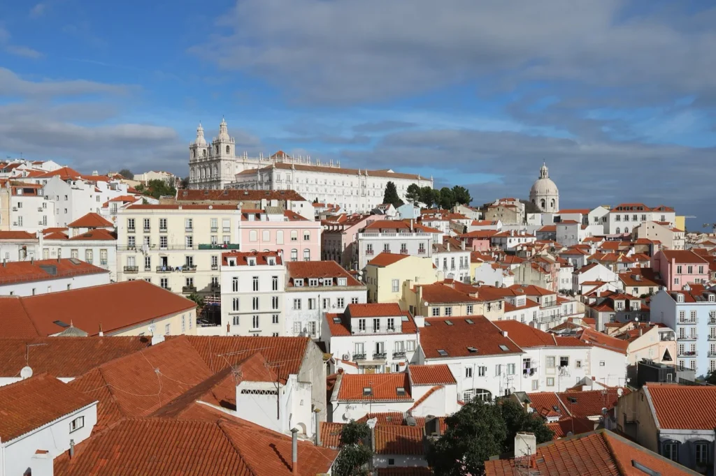 Il quartiere di Alfama visto dal Miradouro de Santa Luzia: tetti rossi e case bianche sotto un cielo azzurro