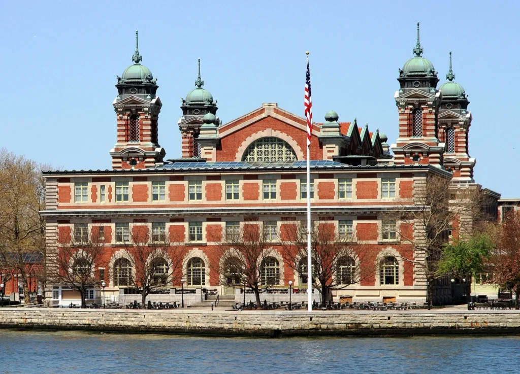 L'edificio principale di Ellis Island, in mattoni rossi con torri a cupola, visto dall'acqua