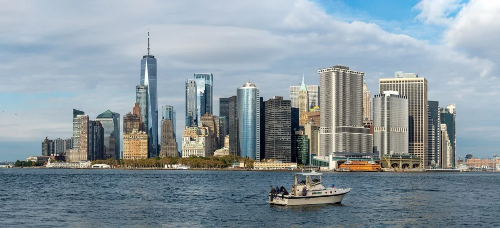 Lo skyline di Lower Manhattan visto da Governors Island, con una barca da pesca sull'acqua in primo piano
