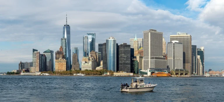 Lo skyline di Lower Manhattan visto da Governors Island, con una barca da pesca sull'acqua in primo piano
