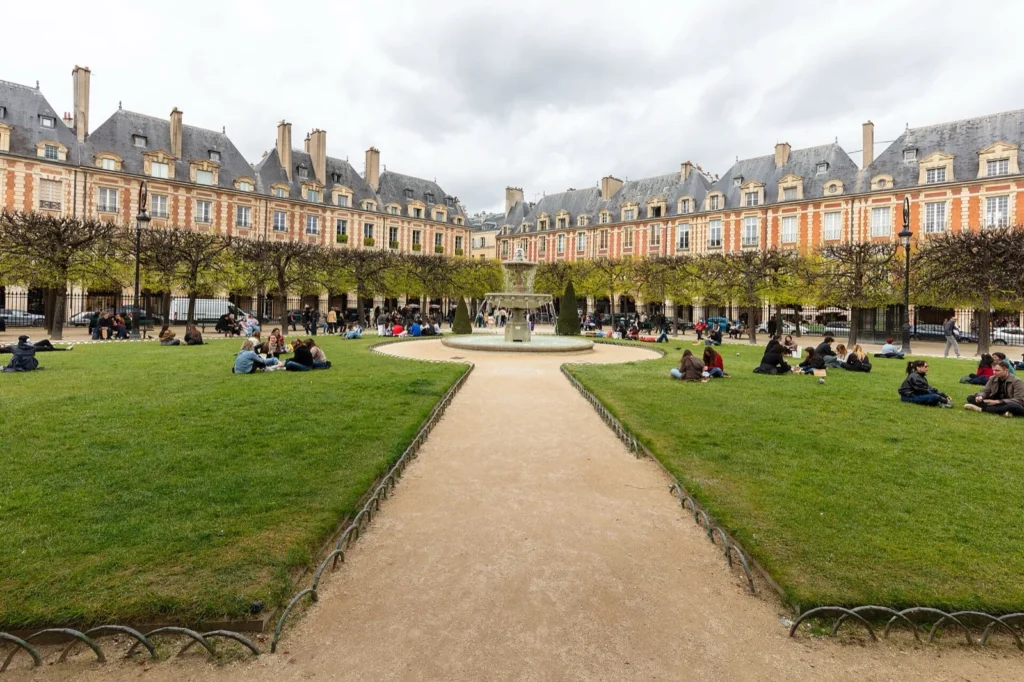 Place des Vosges nel Marais, con la fontana, i prati e i palazzi in mattoni rossi